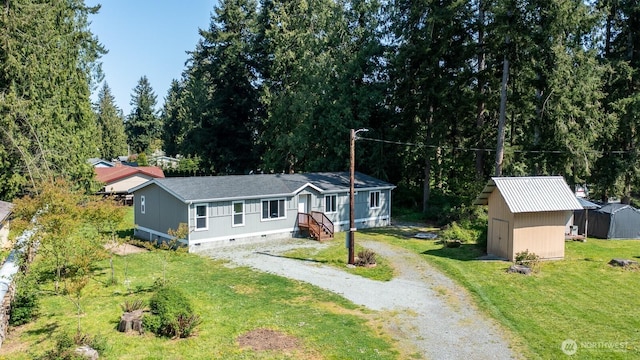 view of front of property with a shed, crawl space, driveway, an outdoor structure, and a front yard