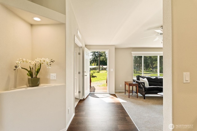 foyer entrance featuring a ceiling fan, baseboards, and dark wood-type flooring