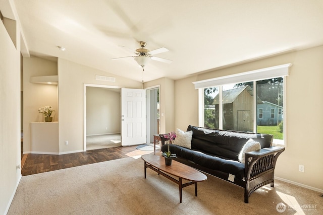 living area featuring vaulted ceiling, baseboards, visible vents, a ceiling fan, and carpet floors