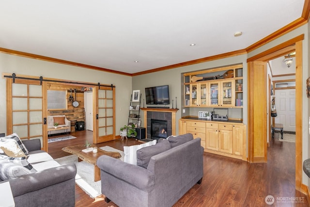 6426 128th Pl SE, Snohomish, WA 98296 - living area with a barn door, dark wood-style floors, crown molding, a tiled fireplace, and baseboards