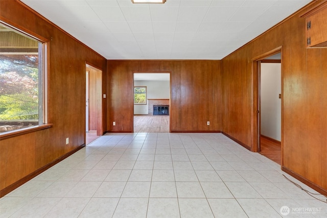 unfurnished room featuring wooden walls and baseboards