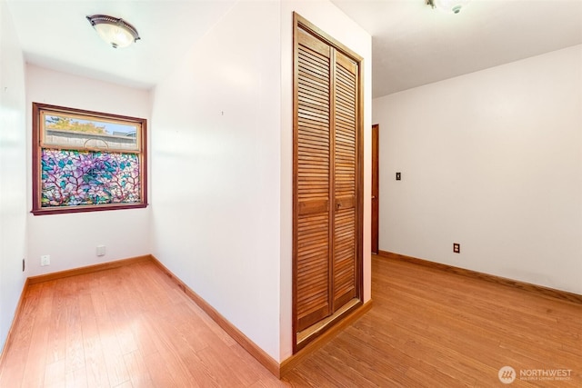 hall featuring baseboards and light wood-style flooring