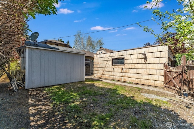 view of yard featuring an outdoor structure, fence, and a shed