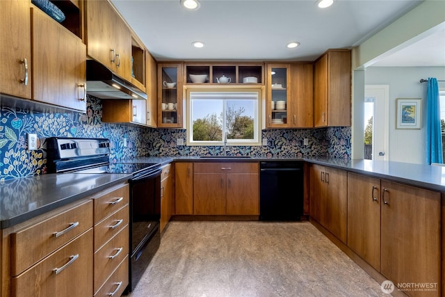 kitchen featuring black appliances, under cabinet range hood, brown cabinetry, and a sink