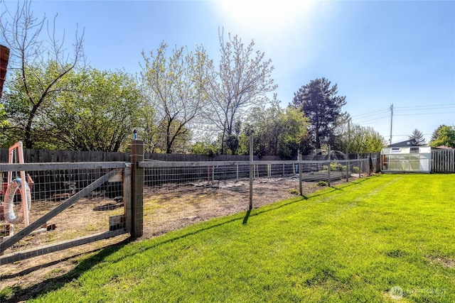 view of yard with an outdoor structure, a storage shed, and fence