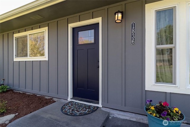 doorway to property with board and batten siding and a porch