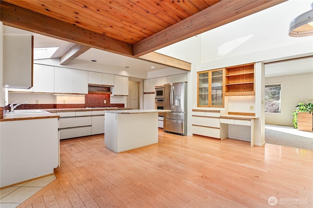 3884 Fort Bellingham Rd, Bellingham, WA 98225 - kitchen featuring white cabinets, stainless steel appliances, a sink, beamed ceiling, and light wood-style floors