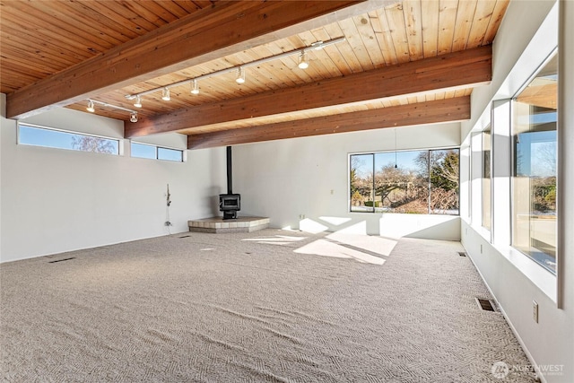 3884 Fort Bellingham Rd, Bellingham, WA 98225 - unfurnished living room featuring carpet floors, a wood stove, a wealth of natural light, and visible vents