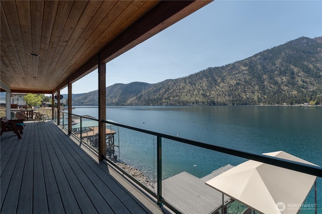 dock area featuring a water and mountain view and a balcony
