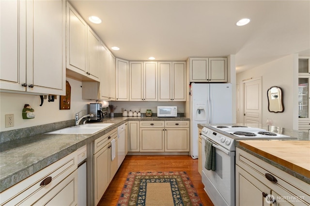 kitchen with light wood finished floors, recessed lighting, a sink, white appliances, and wooden counters