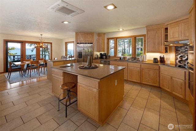 1378 San Juan Dr, San Juan Island, WA 98250 - kitchen with appliances with stainless steel finishes, a kitchen island, under cabinet range hood, a sink, and light brown cabinetry