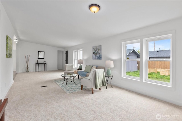 carpeted living area with baseboards