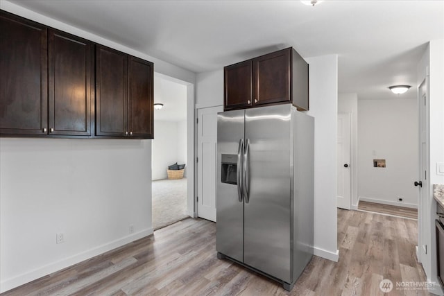 kitchen featuring light wood-style flooring, baseboards, dark brown cabinetry, and stainless steel fridge with ice dispenser