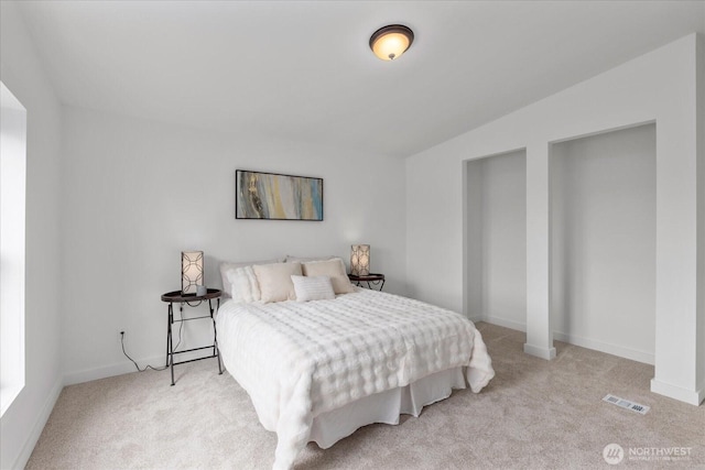 carpeted bedroom featuring visible vents and baseboards