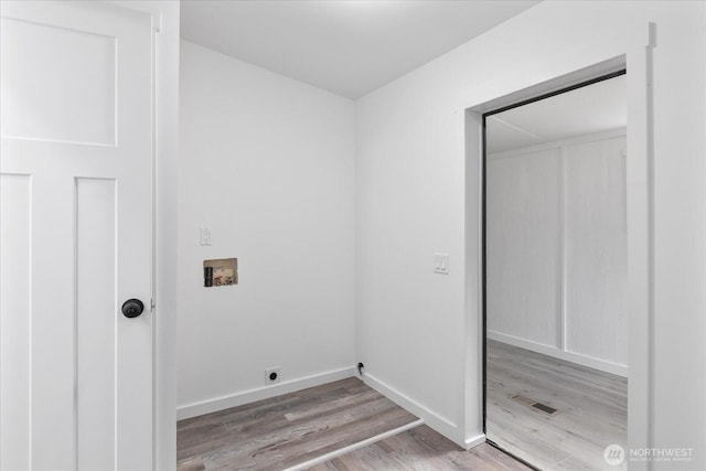 clothes washing area with visible vents, washer hookup, wood finished floors, electric dryer hookup, and laundry area