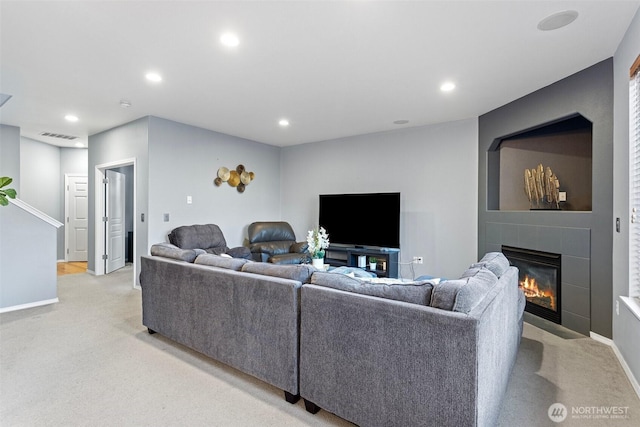 living area with light colored carpet, a tile fireplace, visible vents, and recessed lighting