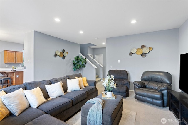 living area with stairway, recessed lighting, and light colored carpet