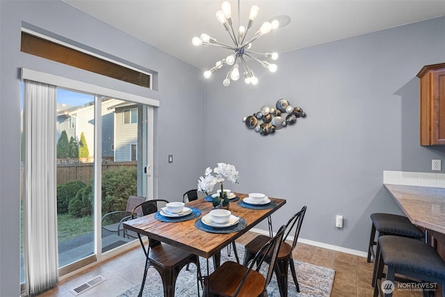 dining room featuring a wealth of natural light, light tile patterned flooring, a chandelier, and visible vents