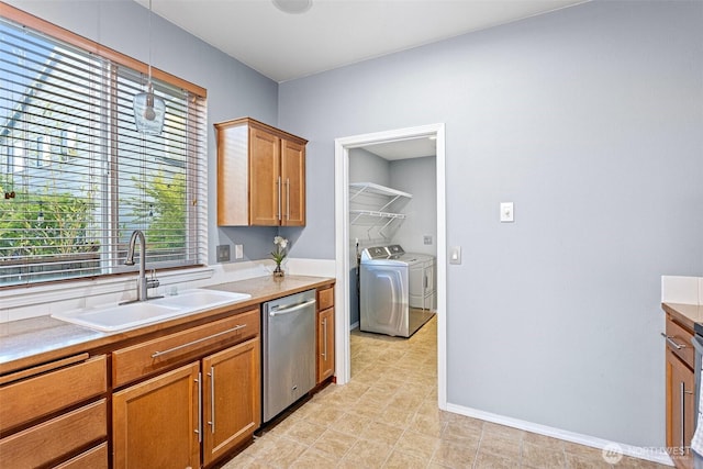kitchen featuring dishwasher, washing machine and dryer, a sink, and light countertops