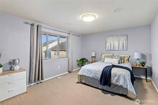 bedroom with baseboards, visible vents, and light colored carpet
