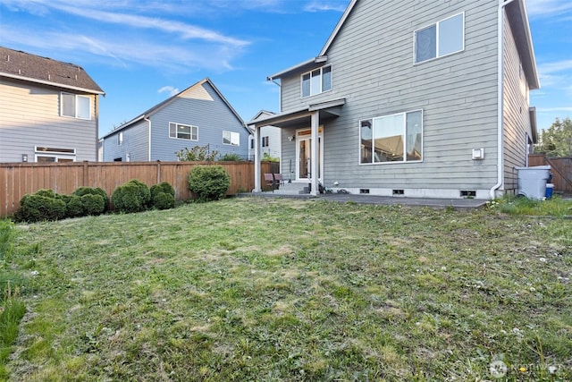 back of property featuring a lawn and a fenced backyard