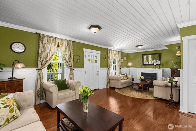 245 SE Bush St, Issaquah, WA 98027 - living room featuring crown molding, a glass covered fireplace, a wainscoted wall, wooden ceiling, and wood finished floors