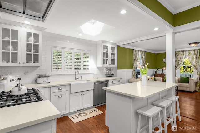 245 SE Bush St, Issaquah, WA 98027 - kitchen with appliances with stainless steel finishes, a sink, crown molding, a skylight, and a kitchen breakfast bar