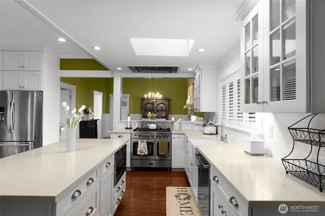 245 SE Bush St, Issaquah, WA 98027 - kitchen with stainless steel appliances, a chandelier, a skylight, light countertops, and recessed lighting