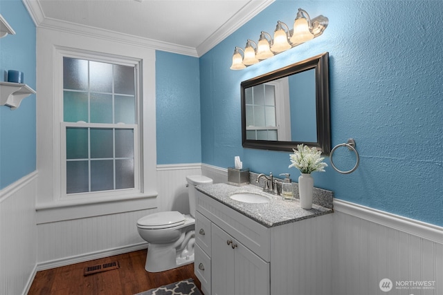 245 SE Bush St, Issaquah, WA 98027 - half bathroom with wood finished floors, a wainscoted wall, toilet, crown molding, and vanity