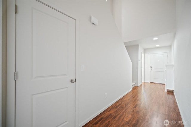 corridor featuring baseboards, dark wood-style floors, and recessed lighting