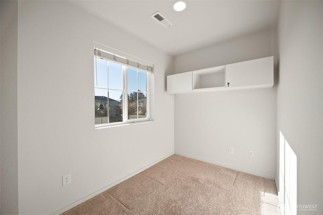 empty room with baseboards, visible vents, and carpet