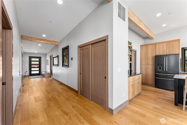 corridor featuring light wood-style flooring, recessed lighting, beam ceiling, and baseboards