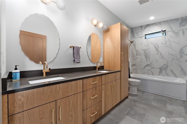 bathroom with toilet, double vanity, and bathtub / shower combination