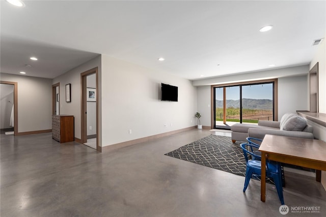 living area featuring finished concrete floors, baseboards, and recessed lighting