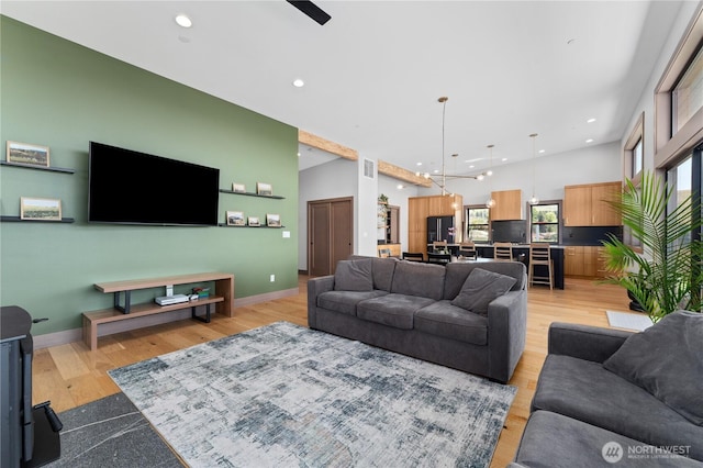 living area with recessed lighting, light wood-type flooring, and baseboards
