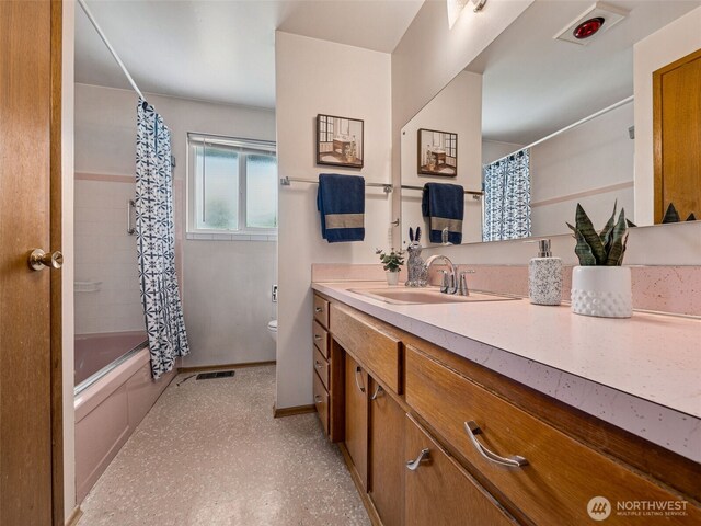 bathroom featuring visible vents, shower / bath combination with curtain, vanity, baseboards, and toilet