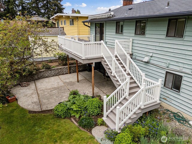 exterior space featuring a patio, a chimney, stairs, and a wooden deck