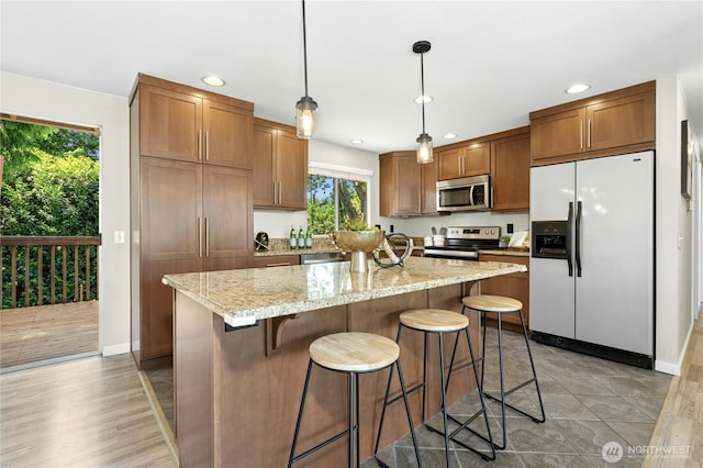 2524 171st St SE, Bothell, WA 98012 - kitchen with appliances with stainless steel finishes, recessed lighting, light stone countertops, a kitchen island, and hanging light fixtures