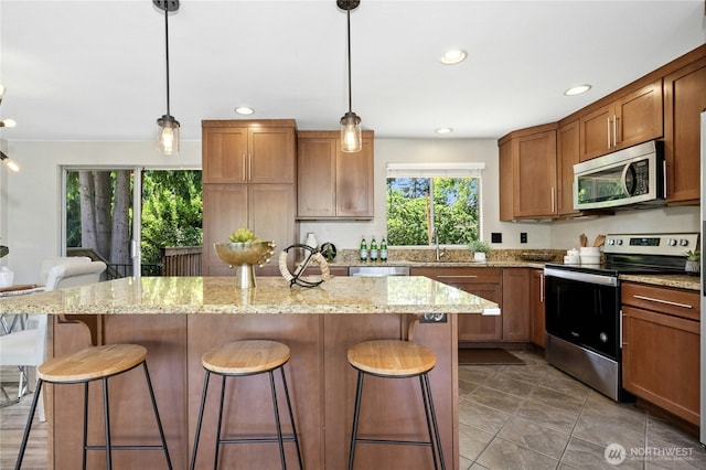 2524 171st St SE, Bothell, WA 98012 - kitchen featuring appliances with stainless steel finishes, a breakfast bar, a kitchen island, decorative light fixtures, and recessed lighting