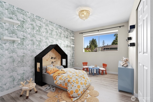 2524 171st St SE, Bothell, WA 98012 - bedroom with wallpapered walls, an accent wall, baseboards, wood finished floors, and a chandelier