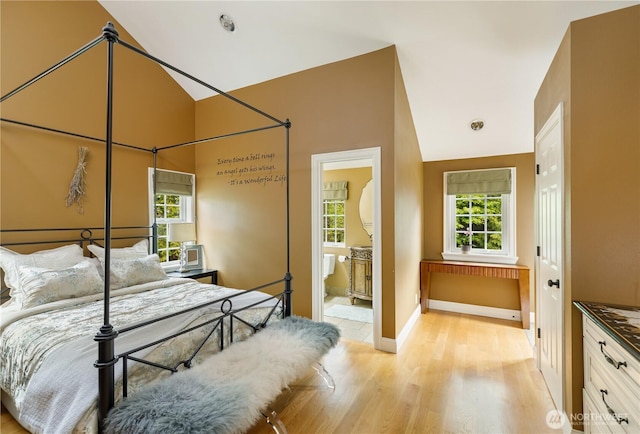 bedroom with baseboards, lofted ceiling, multiple windows, and light wood finished floors