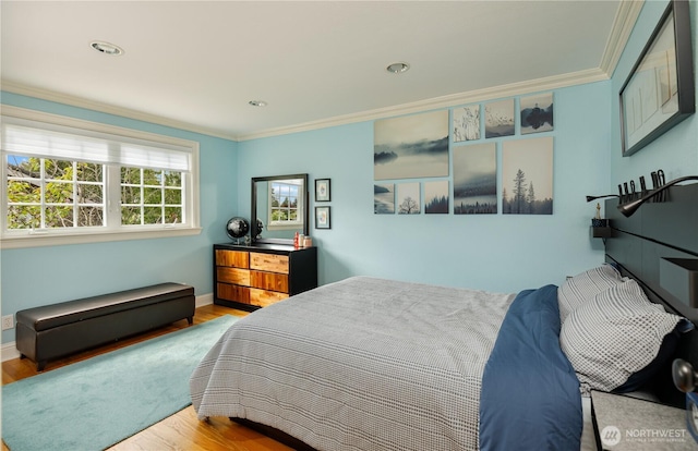 bedroom with crown molding, baseboards, and wood finished floors