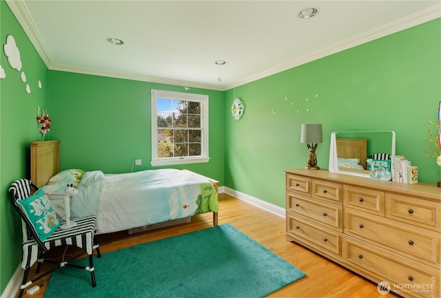 bedroom featuring baseboards, light wood finished floors, and crown molding