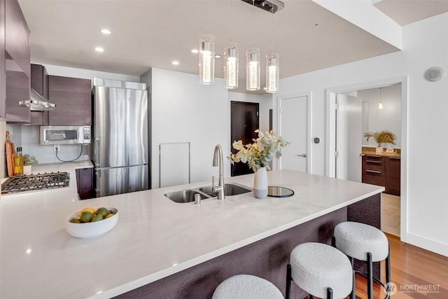 737 Olive Way Unit 3101, Seattle, WA 98101 - kitchen featuring appliances with stainless steel finishes, a sink, a breakfast bar area, light countertops, and recessed lighting