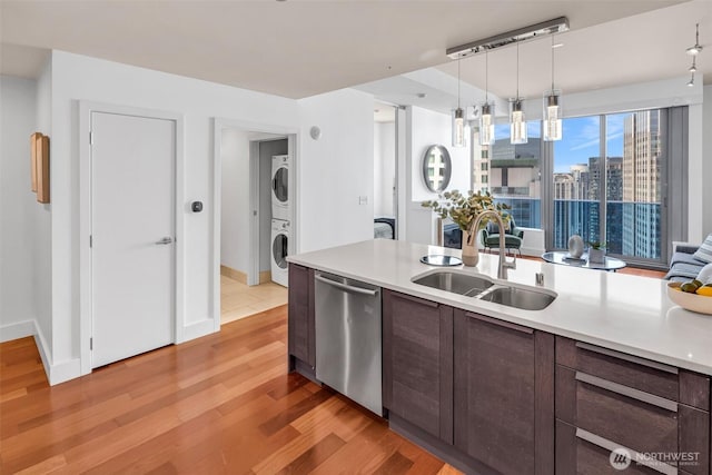 737 Olive Way Unit 3101, Seattle, WA 98101 - kitchen with stainless steel dishwasher, stacked washer and clothes dryer, a sink, and light countertops