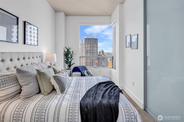 737 Olive Way Unit 3101, Seattle, WA 98101 - bedroom featuring a view of city, baseboards, and carpet floors