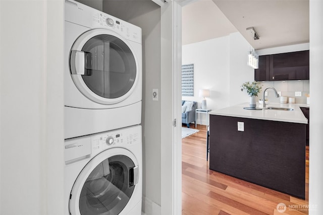 737 Olive Way Unit 3101, Seattle, WA 98101 - laundry area with stacked washer / dryer, a sink, and light wood-style floors
