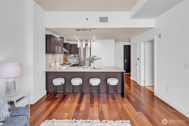 737 Olive Way Unit 3101, Seattle, WA 98101 - kitchen featuring light countertops, light wood finished floors, a kitchen bar, and a peninsula