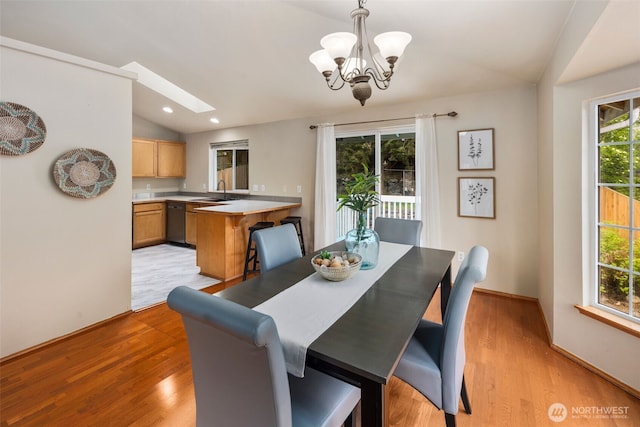 dining space featuring recessed lighting, light wood-style flooring, lofted ceiling with skylight, and a chandelier