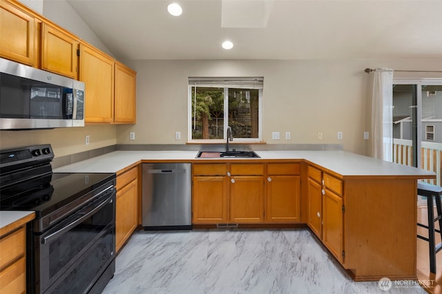 kitchen featuring a sink, light countertops, a peninsula, marble finish floor, and stainless steel appliances